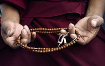 India, West Bengal, Darjeeling, Close cropped shot of hands holding prayer beads.