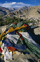 India, Ladakh, Leh , Buddhist prayer flags on hill above valley and town.
