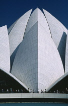 India, New Delhi, Bahai Temple. Part view of lotus flower shaped exterior with line of visitors on walkway in foreground. Completed in 1986 and open to all faiths.