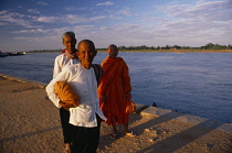 Cambodia, Phnom Penh, Buddhist monk and nuns on waterside.