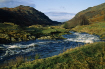 England, Cumbria, Lake District, Watendlath Beck. Fast flowing river running inbetween hills.