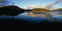 Scotland, Highlands, Loch Shira, View across Loch Shira in evening light with mountains reflected in the water towards Argyll Forest Park.