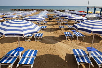 Italy, Sicily, Marina Di Ragusa, Sun umbrellas and sun beds on a beach.