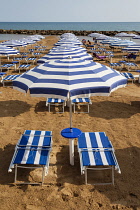 Italy, Sicily, Marina Di Ragusa, Sun umbrellas and sun beds on a beach.