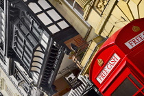 England, Cheshire, Chester, Iconic red telephone box converted to ATM on Eastgate Street with black and white architecture behind.