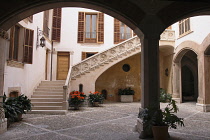 Spain, Balearic Islands, Majorca, Palma, Stone stairs with bas-relief figures in an old town courtyard.