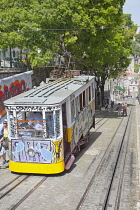 Portugal, Estremadura, Lisbon, Bairro Alto, Elevador da Gloria, Funicular railway tram covered in graffiti.