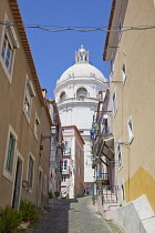 Portugal, Estredmadura, Lisbon, Alfama district, View up narrow street toward Dome of the National Pantheon.