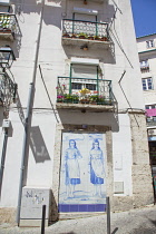 Portugal, Estredmadura, Lisbon, Alfama district, Traditional Hand Painted Azulejos Tile Mural Panel outside laundromat.