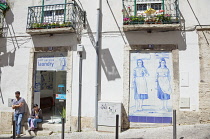 Portugal, Estredmadura, Lisbon, Alfama district, Traditional hand painted Azulejos tile mural panel outside laundromat.