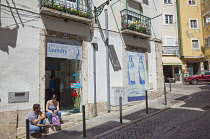 Portugal, Estredmadura, Lisbon, Alfama district, Traditional hand painted Azulejos tile mural panel outside laundromat.