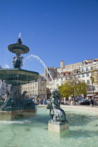 Portugal, Estremadura, Lisbon, Baixa, Praca Rossio with fountain and Statue of King Pedro IV in the centre of the square.