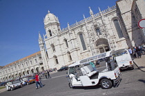 Portugal, Estredmadura, Lisbon, Belem, Mosterio Dos Jeronimos, Exterior of the monastery with Tuk Tuks parked.