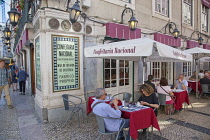 Portugal, Estremadura, Lisbon, Baixa district, Tourists sat at tables outside Confeitaria Nacional cafe.