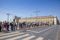 Portugal, Estremadura, Lisbon, Baixa, Praca do Comercio with queue of tourists awaiting tram.