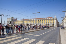 Portugal, Estremadura, Lisbon, Baixa, Praca do Comercio with queue of tourists awaiting tram.