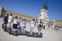 Portugal, Estremadura, Lisbon, Baixa, Praca do Comercio, Segway guided tour of the square with equestrian statue of King Jose and Rua Augusta triumphal arch.