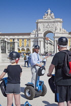 Portugal, Estremadura, Lisbon, Baixa, Praca do Comercio, Segway guided tour of the square with equestrian statue of King Jose and Rua Augusta triumphal arch.