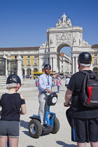 Portugal, Estremadura, Lisbon, Baixa, Praca do Comercio, Segway guided tour of the square with equestrian statue of King Jose and Rua Augusta triumphal arch.