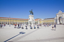 Portugal, Estremadura, Lisbon, Baixa, Praca do Comercio, Segway guided tour of the square with equestrian statue of King Jose and Rua Augusta triumphal arch.