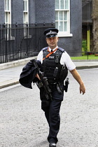 Law & Order, Police officer carrying firearm in Downing Street, Westminster, London, England.