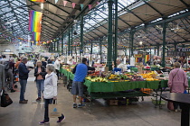 Ireland, North, Belfast, St George's Market interior, Fruit and veg stalls with rainbow flags above.