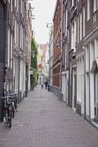 Holland, North, Amsterdam, Bicycle parked in typical narrow cobbled street.