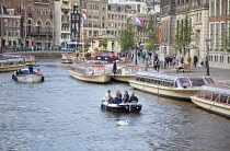 Holland, North, Amsterdam, Tourists on canal tour boats.