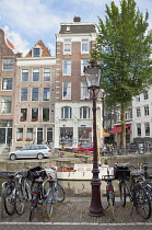 Holland, North, Amsterdam, Bicycles parked next to canal.