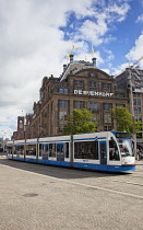 Holland, North, Amsterdam, Dam Square, Tram passing De Bijenkorf department store.