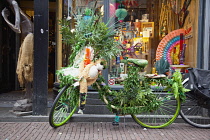 Holland, North, Amsterdam, Bike decorated with dope leaves outside shop.