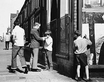 England, Merseyside, Bootle, Young boy cadging a light for a cigarette, 1968.