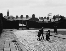 England, Merseyside, Kirkdale, Children playing soccer on cobbled street, 1972.