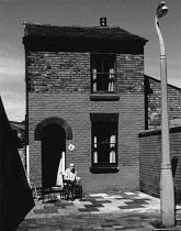 England, Merseyside, Southport, Old man sat in wheelchair outside house in Railway Terrace, 1974.