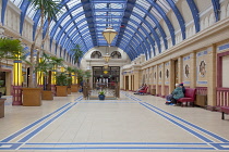 England, Lancashire, Blackpool, Winter Gardens interior with tiled floor, glass roof and palm trees.