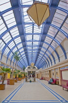 England, Lancashire, Blackpool, Winter Gardens interior with tiled floor, glass roof and palm trees.