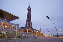 England, Lancashire, Blackpool, Seafront promenade with Tower at dusk.