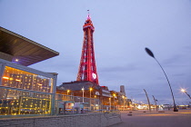 England, Lancashire, Blackpool, Seafront promenade with Tower illuminated at dusk.