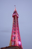 England, Lancashire, Blackpool, Seafront promenade with Tower illuminated at dusk.