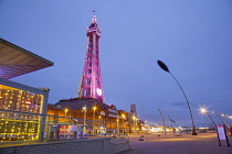 England, Lancashire, Blackpool, Seafront promenade with Tower illuminated at dusk.