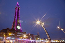 England, Lancashire, Blackpool, Seafront promenade with Tower illuminated at dusk.