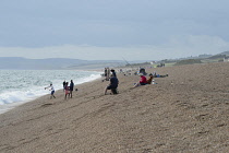 England, Dorset, Portland, Chesil Beach, Anglers fishing from the pebble beach.