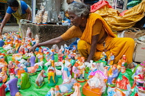 India, Pondicherry, Street vendor arranging a display of nativity figures for sale.