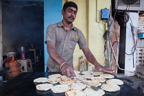 India, Pondicherry, Man frying parathas at a food hotel.
