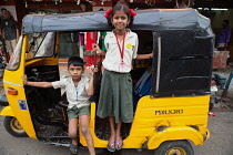 India, Pondicherry, A brother and sister in school uniform in a motor rickshaw in Pondicherry.