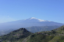 Italy, Sicily, Mount Etna on the horizon with steam rising from its peak.