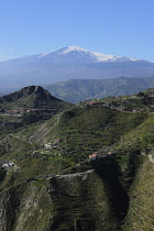 Italy, Sicily, Mount Etna on the horizon with steam rising from its peak.