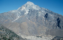 Nepal, Khumbu, Village near Namche bazar at foot of jagged, barren mountain with scree slopes cris-crossed with narrow tracks and crevices.