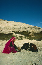 Qatar, General, Bedouin women grinding wild herbs using a pestle and mortar.