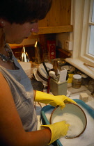 Cleaning, Woman washing dishes kitchen sink.